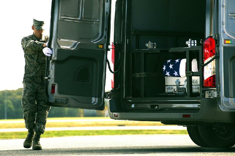 U.S. Air Force Senior Airman Brandon North closes the door to a vehicle carrying the body of U.S. Army Sgt. Douglas Riney, 26, of Fairview, Ill., who was killed this week in Afghanistan. His remains were returned Friday to Dover Air Force Base in Delaware.