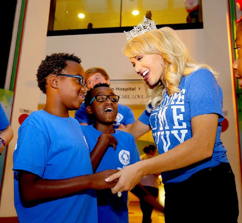 Miss America Savvy Shields visits with Trent Hollon (left) and his twin brother Trey, both 11, at an event Friday at Arkansas Children’s Hospital in Little Rock. Shields, 21, of Fayetteville, returned Thursday to her home state with a parade in Little Rock. A second homecoming parade is planned for her today in Fayetteville. 