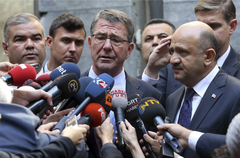 U.S. Secretary of Defense Ash Carter (center) speaks to the media Friday after he left flowers near the damaged section of the Turkish parliament bombed during the July 15 failed coup in Ankara, Turkey.