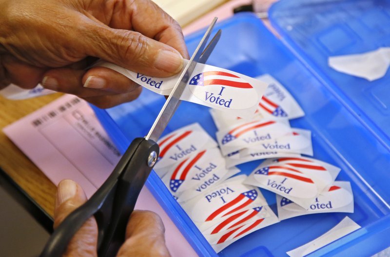 In this June 28, 2016 file photo, an elections clerk cuts from a strip of "I Voted" stickers at a polling place in Oklahoma City. Officials in Oklahoma, Texas and Louisiana say they've denied a request by Russian officials to be present at polling stations during next month's election. 