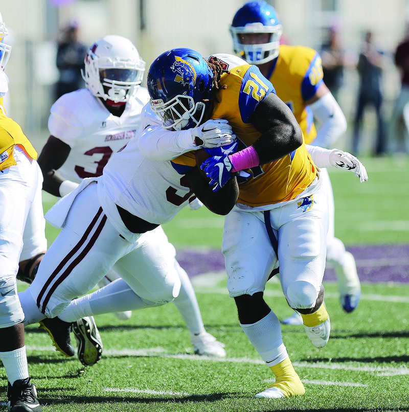 SAU running back Michael Nunnery tries to get away from Henderson State's Josh Davis. Davis, of El Dorado, had eight tackles for the Reddies, who fell to the Muleriders 50-24 Saturday in the Murphy USA Classic at Memorial Stadium.