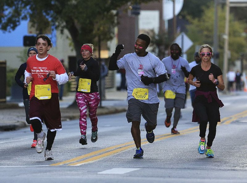 Participants approach the fi nish line near Third Street and Louisiana Avenue in Little Rock during the Susan G. Komen Race for the Cure 5K on Saturday. An estimated 23,000 people participated in the annual fundraiser for breast cancer research.