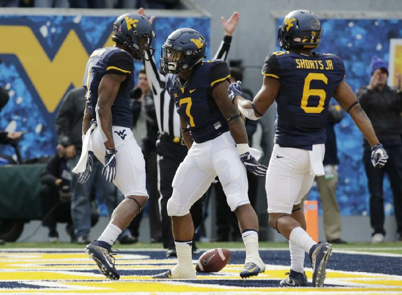 West Virginia running back Rushel Snell (middle) celebrates with wide receiver Shelton Gibson (left) and Daikiel Shorts after scoring a touchdown during the No. 12 Mountaineers’ 34-10 victory over TCU on Saturday in Morgantown, W.Va.