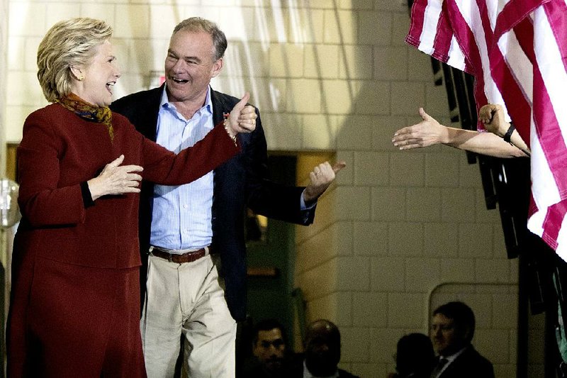 Hillary Clinton and Tim Kaine arrive for an event Saturday at a high school in Pittsburgh. In an interview, Kaine expressed optimism that if he and Clinton win the election, they will be able to work with Republicans.