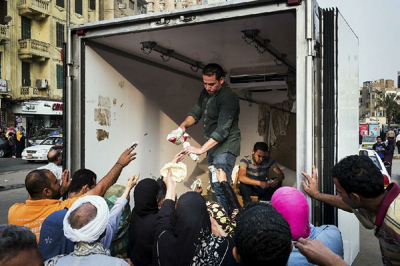 Workers from Egypt’s Ministry of Supply sell subsidized sugar to desperate buyers outside a mosque in Cairo.