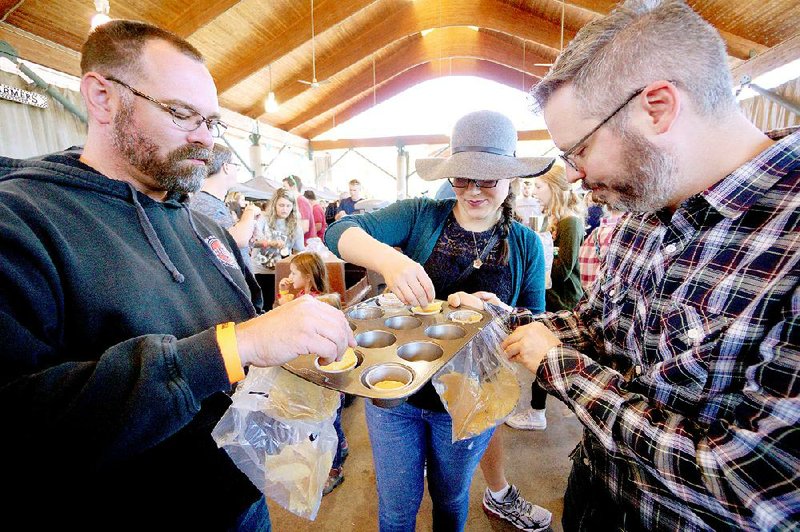 Arkansas Democrat-Gazette/MITCHELL PE MASILUN --10/22/2016--
Left to right, Bruce Moyer of Romance, Beren DeHaven of Little Rock, and Holland Gould of Little Rock, enjoy the different flavors during the World Cheese Dip Championship at River Market Pavillion Saturday, October 22, 2016.