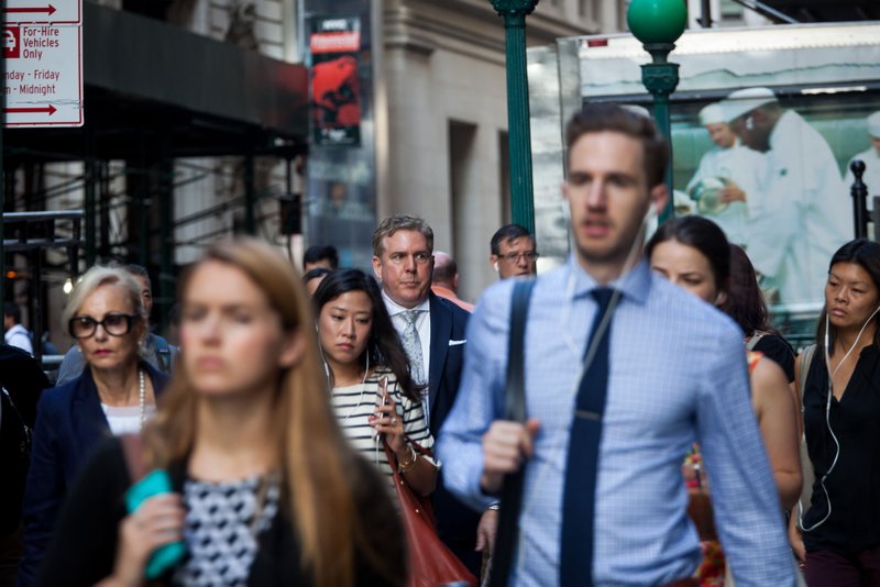 American workers, many like these walking on Wall Street in New York in August, work longer hours than their European counterparts, a study shows.