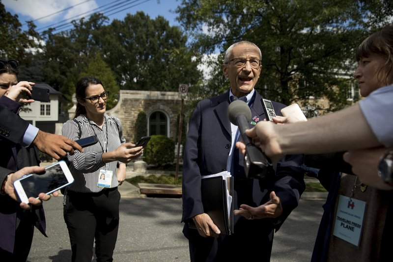 In this photo taken Oct. 5, 2016, Hillary Clinton's campaign manager John Podesta speaks to members of the media outside Democratic presidential candidate Hillary Clinton's home in Washington.