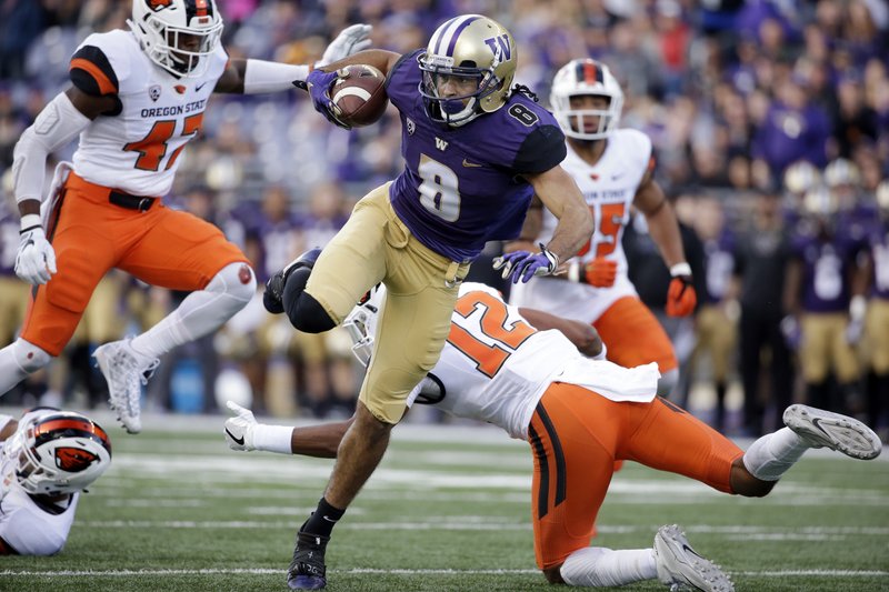 Washington's Dante Pettis (8) twists to avoid Oregon State defenders as he scores on a 23-yard pass reception in the first half of an NCAA college football game Saturday, Oct. 22, 2016, in Seattle. 