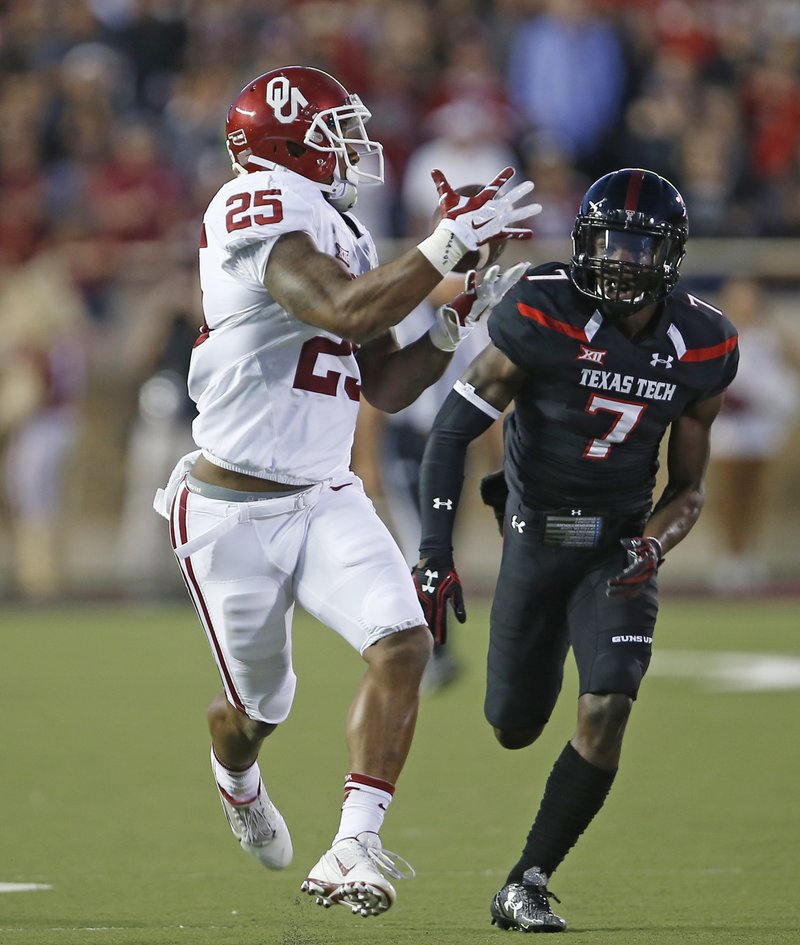 Oklahoma's Joe Mixon (25) catches a touchdown pass in front of Texas Tech Jah'Shawn Johnson (7) during an NCAA college football game Saturday, Oct. 22, 2016, in Lubbock, Texas. 