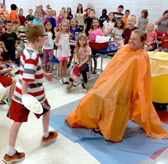 Submitted photo Cutter Morning Star Elementary School student Jacob Felton, left, prepares to throw a pie into the face of Heather Hughes, library media specialist. Students who read at least 50 hours in the Garland County Library Summer Reading Program were entered into a drawing to throw the pie. All students who participated in the program attended the assembly and received a prize.