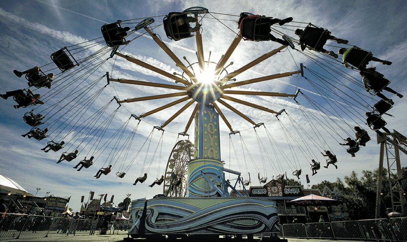 Arkansas Democrat-Gazette/MITCHELL PE MASILUN Fairgoers enjoy a spin on the Yolo ride on the last day of the Arkansas State Fair on Sunday in Little Rock.