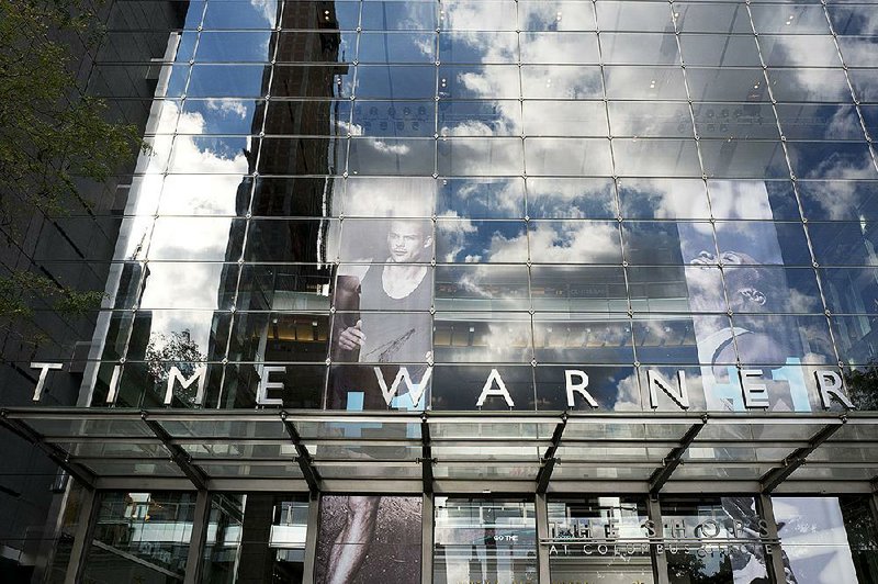 Clouds are reflected Monday in the glass facade of the Time Warner building in New York. AT&T plans to buy the company in a deal valued at $108.7 billion.