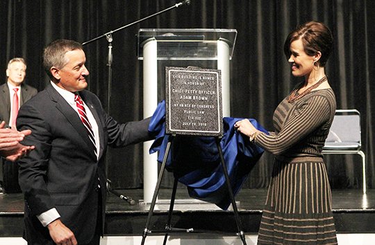 The Sentinel-Record/Richard Rasmussen IN HIS HONOR: U.S. Rep. Bruce Westerman, R-District 4, left, and Kelley Brown, widow of hometown war hero Adam Brown, unveil a plaque Monday renaming the downtown Hot Springs post office the Chief Petty Officer Adam Brown United States Post Office during a ceremony at Hot Springs Convention Center.