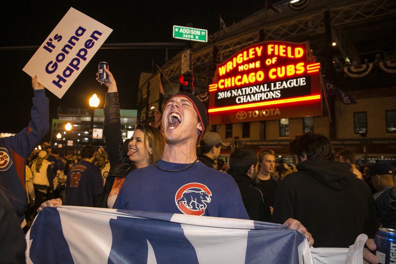 The Associated Press SPENDING SPREE: Cubs fans celebrate outside Wrigley Field after Chicago clinches its first National League pennant in 71 years with a 5-0 victory over the Los Angeles Dodgers Saturday night. Fans hoping to see the Cubs play in the World Series for the first time since 1945 are finding that a seat will cost them what their grandparents paid for their houses.