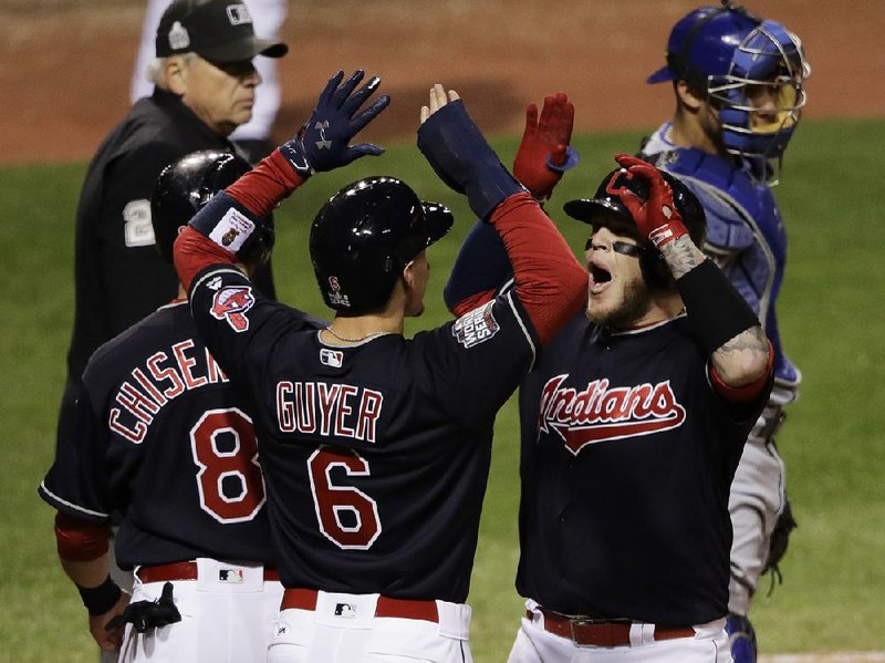 Cleveland catcher Roberto Perez (right) is greeted by teammates Brandon Guyer (center) and Lonnie Chisenhall after hitting his second home run Tuesday night to power the Indians past the Chicago Cubs 6-0 and grab a 1-0 lead in the World Series.