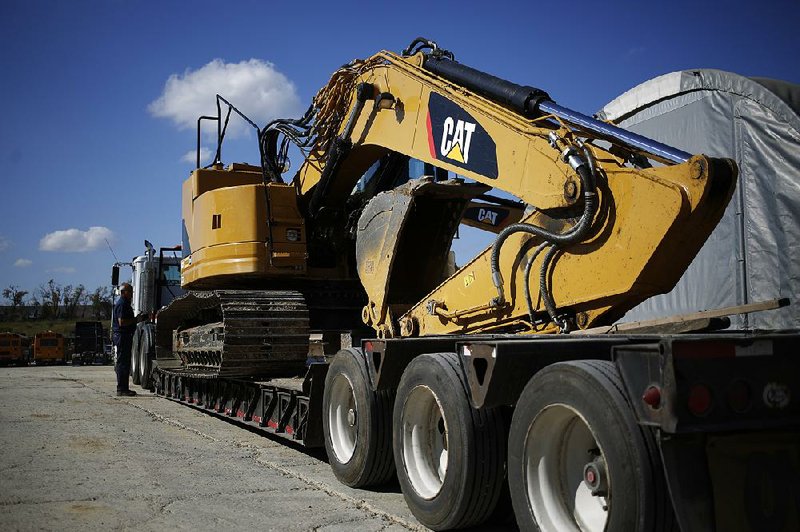 An employee checks a Caterpillar Inc. rental excavator loaded on a flatbed trailer at the Whayne Supply Co. dealership in Lexington, Ky., on Oct. 17. Caterpillar on Tuesday reported a third-quarter profit of $283 million. 