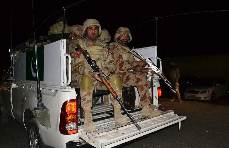 Pakistani troops arrive early Tuesday at a police training school near Quetta after militants stormed the school in a bloody assault. The militants died in clashes with Pakistani forces.