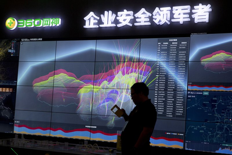 In this Aug. 16, 2016 file photo, a worker is silhouetted against a computer display showing a live visualization of the online phishing and fraudulent phone calls across China during the 4th China Internet Security Conference (ISC) in Beijing. 