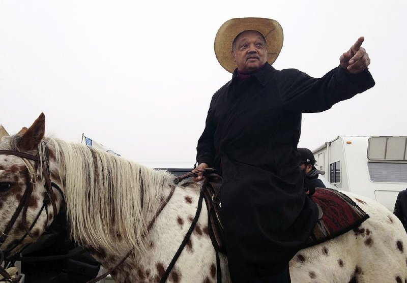 Activist Jesse Jackson visits the pipeline protesters’ campsite on horseback Wednesday outside Cannon Ball, N.D. Jackson said he was there “to pray together, protest together and if necessary go to jail together.”