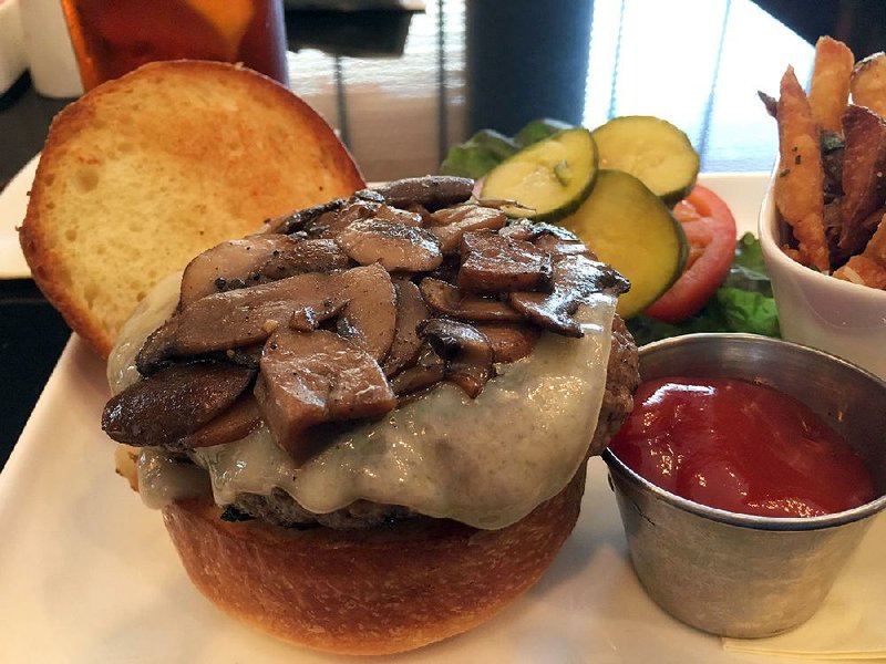 The Burger, a 7-ounce patty of in-house ground, all natural beef, with Swiss cheese and sauteed mushrooms, comes with a side of parmesan fries at the Capital Bar & Grill. 