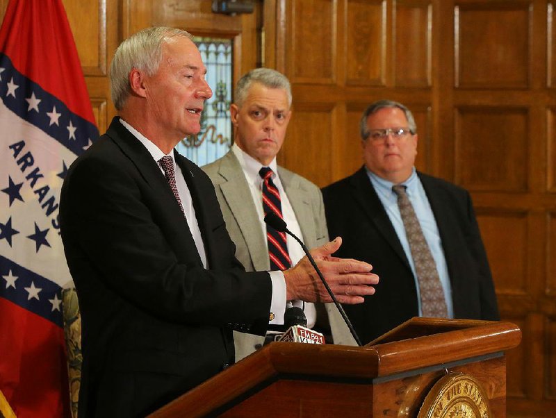 Gov. Asa Hutchinson (from left) explains his plan for War Memorial Stadium at a news conference Tuesday with Kane Webb, state Department of Parks and Tourism director, and Jerry Cohen, War Memorial Stadium Commission executive director.