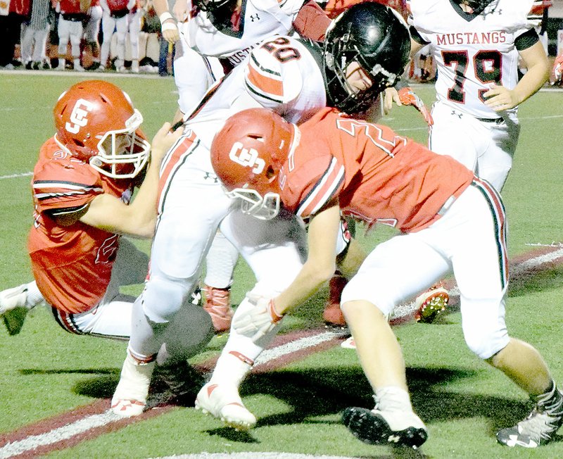 PHOTO BY RICK PECK McDonald County running back Jake Will fights for extra yards before being brought down by Carl Junction&#8217;s Austin Sullivan (left) and Zach Hills during the Mustangs&#8217; 56-12 loss on Friday night at Carl Junction High School.