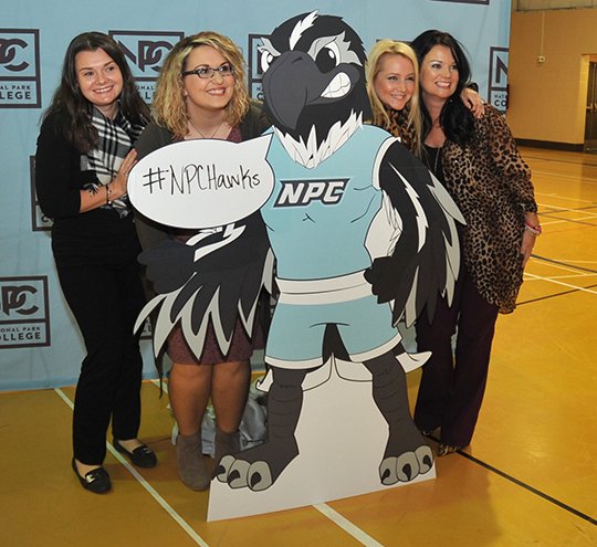 The Sentinel-Record/Mara Kuhn NIGHTHAWKS: National Park College staff members, from left, Amy Watson, Chelsea Lairamore, Anne Benoit and Tennille Johnson display a rendering of a costume for the school's new mascot, Nighthawks, announced during a pep rally Wednesday in the NPC Wellness Center gymnasium. The hashtag #NPCHawks can be used on social media to discuss the new mascot.