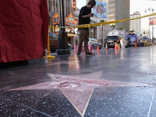 A man stands near a cordoned off area surrounding the vandalized star for Republican presidential candidate Donald Trump on the Hollywood Walk of Fame, Wednesday, Oct. 26, 2016, in Los Angeles. 