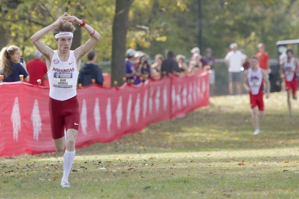 Alex George, a junior at the University of Arkansas, forms an A with his fingers as he approaches the finish line in first place Friday, October 28, 2016, at the Southeastern Conference Championship held at Agri Park in Fayetteville. Both the Razorback men and women won their respective conference titles.
