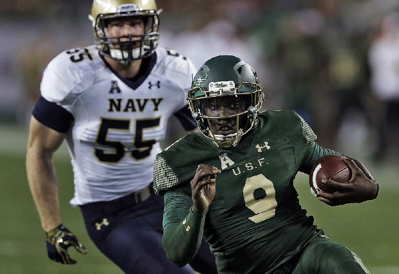 South Florida quarterback Quinton Flowers (9) runs past Navy linebacker Ted Colburn (55) during the third quarter of the Bulls’ 52-45 victory over the No. 22 Midshipmen on Friday in Tampa, Fla. Flowers ran for 176 yards and 2 touchdowns on 13 carries in the victory.