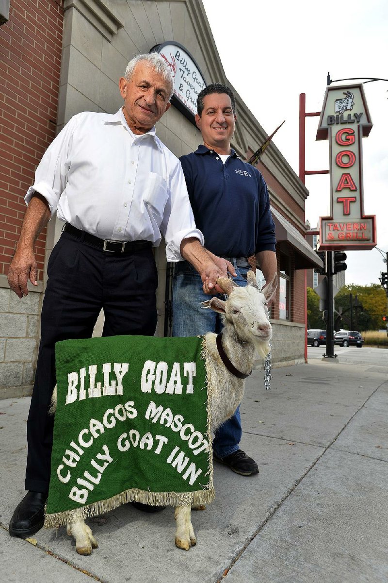 Billy Goat Tavern owners Sam Sianis (left) and his son Bill pose with “Billy” the goat outside their tavern on Madison Street in Chicago.