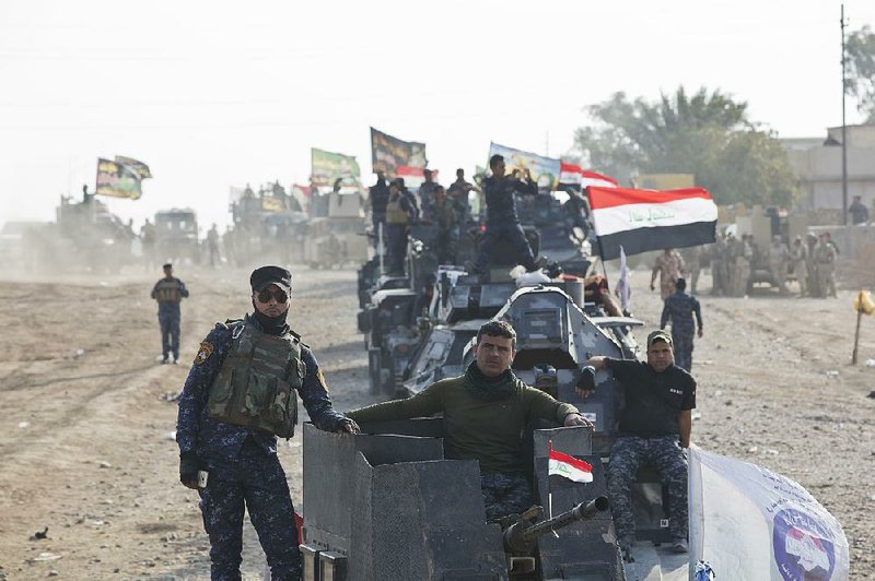 Iraqi federal police officers watch air and ground strikes slam Shura on Saturday as Iraqi troops move in on their way to Mosul. U.S.-led airstrikes and artillery fire targeted Islamic State positions inside Shura.