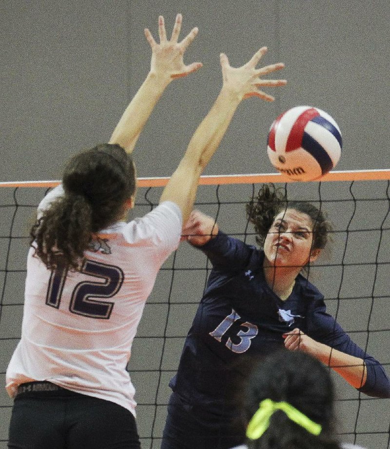 Springdale Har-Ber’s Jaden Williams (right) delivers a spike past Fayetteville’s Faith Waitsman during Saturday’s match.