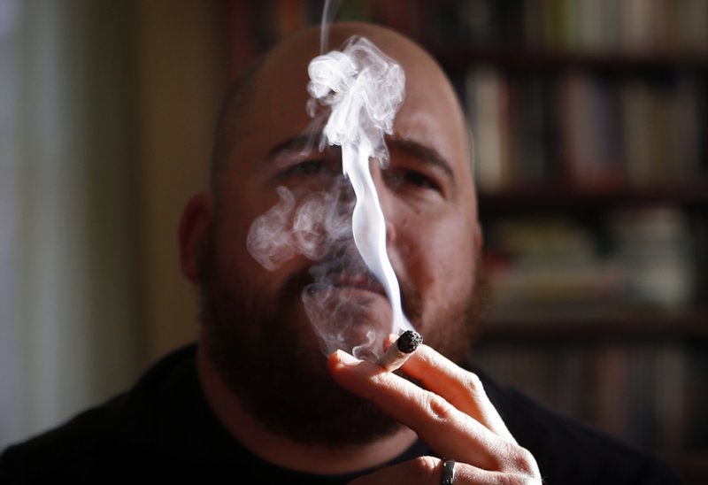 In this Nov. 21, 2014, file photo, a former U.S. Marine smokes medical marijuana in Belfast, Maine. 