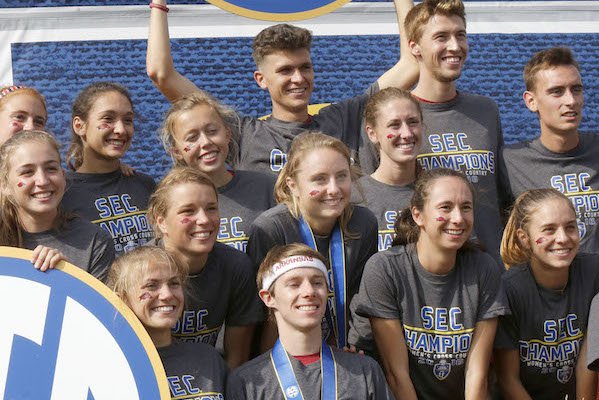 Devin Clark (center), a sophomore at the University of Arkansas and second place finisher, stands above Alex George, a junior at the University of Arkansas and first place finisher and their teammates Friday, October 28, 2016, at the Southeastern Conference Championship held at Agri Park in Fayetteville. Both the Razorback men and women won their respective team conference titles.