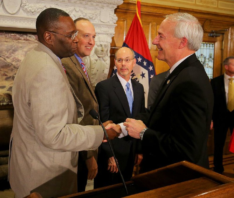 Henderson State University President Glendell Jones Jr. (from left), Arkansas State University President Charles Welch and University of Arkansas System President Donald Bobbitt talk with Gov. Asa Hutchinson after Hutchinson’s announcement Monday of a planned increase in higher-education funding.