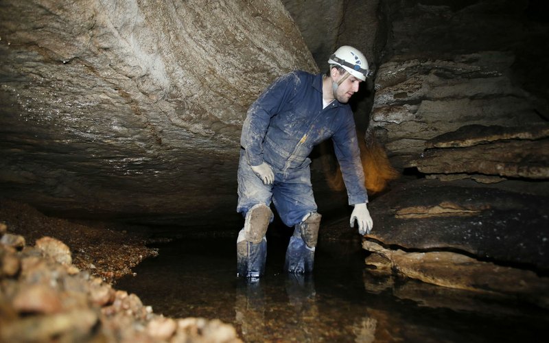 Guy Schiavone, general manager and guide, is illuminated by a headlamp and flashlight before reentering the Mirror Lake room after leading a tour on the Wild Tour of War Eagle Cavern on Beaver Lake. The Wild Cave Tour gives visitors a guided realistic experience of spelunking that requires helmets, lights, gloves, knee pads and the willingness to get muddy and possibly wet.