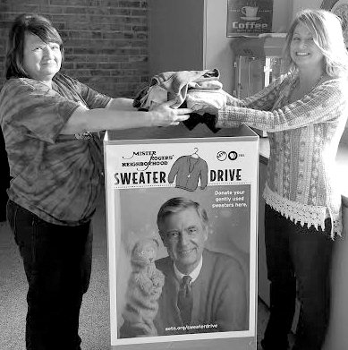 Submitted Photo Jackie Whitehead and Lori Johnston placed the first sweaters into the collection box at Gentry Public Library last week to kick off the local sweater drive.