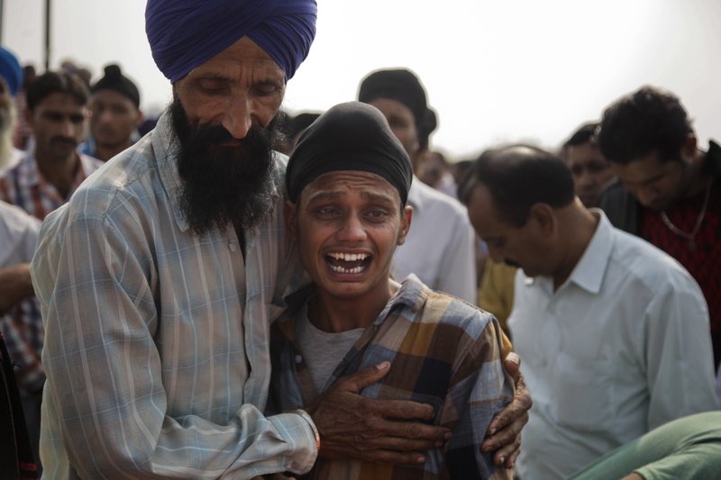Brother of Indian woman Rajinder Kaur, who was killed in Pakistani shelling, wails during her funeral at Khour village in Ramgarh sector, Samba district of Jammu and Kashmir, India, Tuesday, Nov.1, 2016.