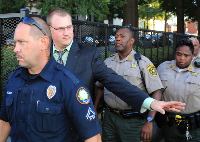 FILE — Former Little Rock police officer Josh Hastings waves to some Little Rock Police officers as he is escorted out of the Pulaski County Courthouse after his manslaughter trial ended in a 2nd mistrial in 2013.