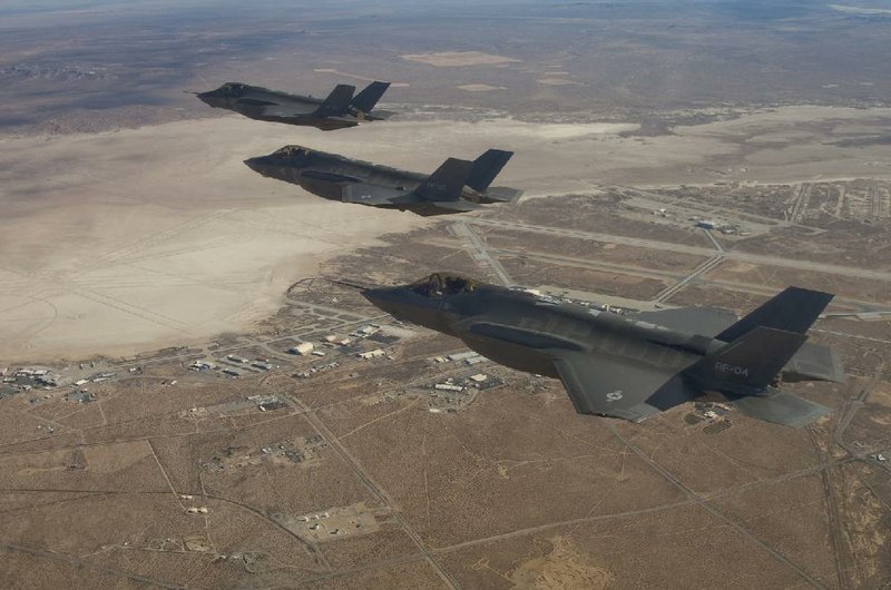 Three F-35 fighters fly over Edwards Air Force Base, Calif., during testing in December 2013. The development phase for the aircraft, originally set to end in 2012, likely will continue to November 2018, officials said. 