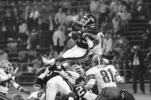 Arkansas' running back Gary Anderson (43) does a sitting act as he leaps from the one-yard line for a touchdown in the third quarter of the Bluebonnet Bowl game in Houston, Dec. 31, 1982. (AP Photo)