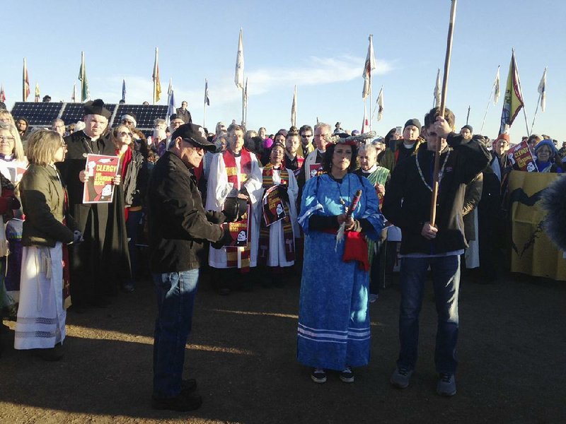 Clergy members from a range of religions join protesters Thursday near Cannon Ball, N.D. A copy of a 600-year-old religious document that sanctioned the taking of Indian land was burned ceremonially. 