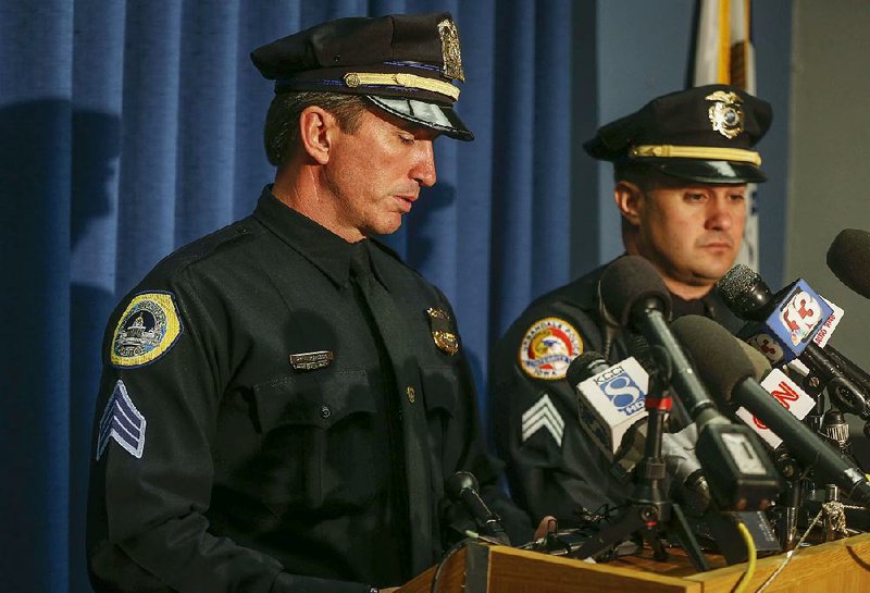 Police Sgt. Paul Parizek (left) becomes emotional Thursday in Des Moines, Iowa, as he updates journalists on the investigation of Wednesday’s fatal shootings of two officers in Des Moines and Urbandale. 