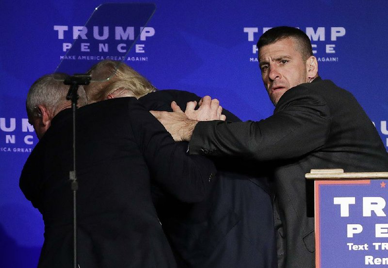 Secret Service agents rush Donald Trump off the stage Saturday while he was speaking at a rally in joh loch
