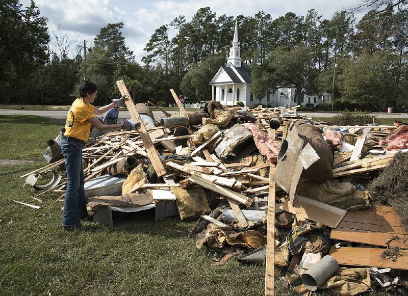 Wendy Gable of Southern Baptist Convention Disaster Relief adds to a pile of ruined materials from a home last month in Nichols, S.C. 