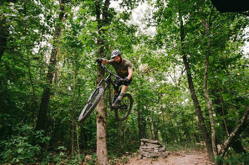 Clayton Woodruff plays on the Coler Creek Trail, which is under construction in Bentonville. A section of the trail will be featured at the International Mountain Bicycling Association World Summit this week.