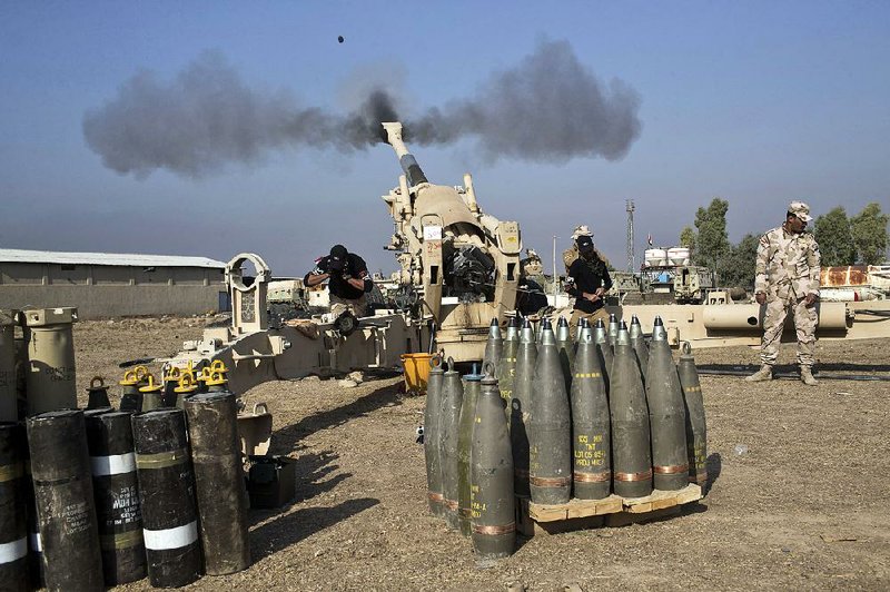Iraqi army soldiers fire an artillery round at Islamic State positions Monday in Bartella, about 9 miles east of Mosul.
