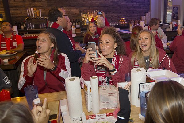 Arkansas soccer players Lindsey Mayo, Cameron Carter and Ellie Breden celebrate during an NCAA Tournament selection show watch party Monday, Nov. 7, 2016, at Sassy's Barbecue & Grille in Fayetteville. 